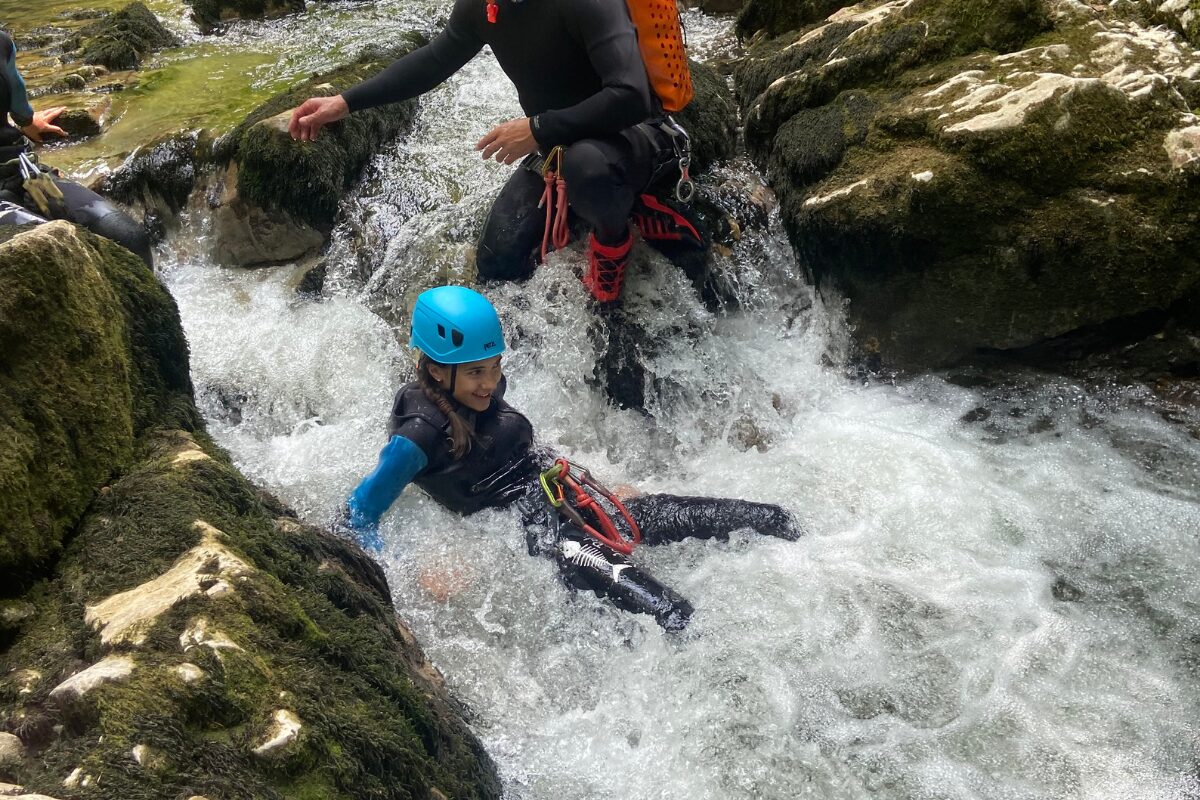 savoir-nager-canyoning-enfant enfant debutant en canyoning encadre par un guide dans le jura