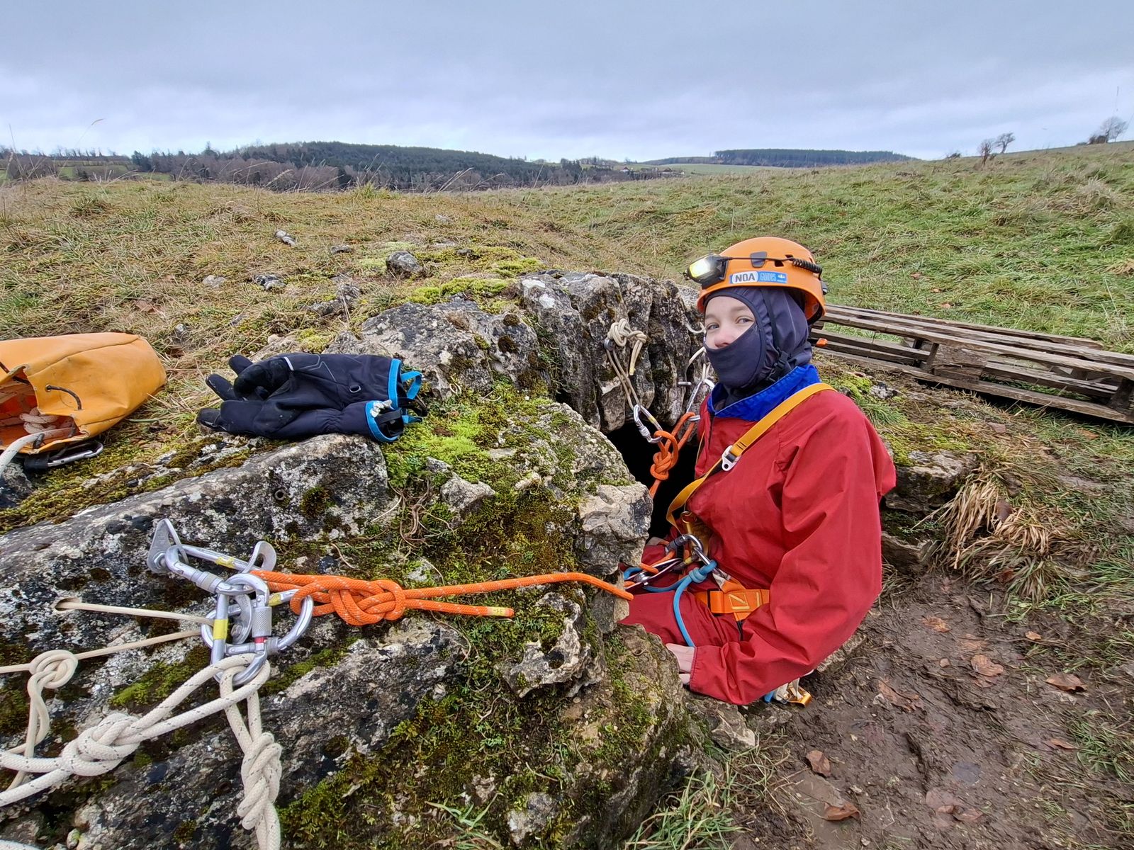 entree-gouffre-plateau-karstique-jura Entrée d’un gouffre sur un plateau calcaire du Jura, avec cordes et matériel de spéléologie