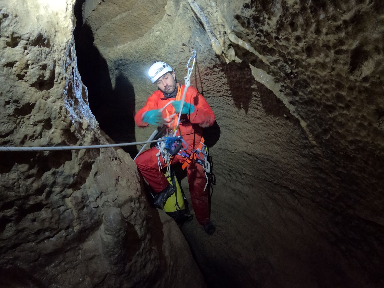 Progression sur corde dans un méandre étroit de la grotte de Balerne