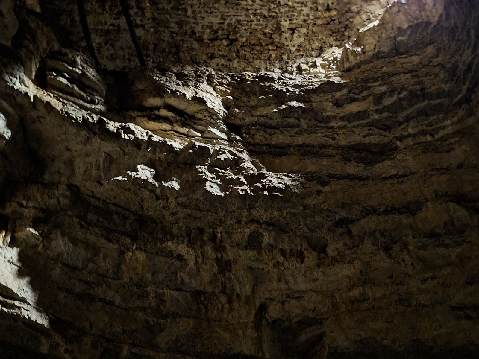 puits-gouffre-des-ravieres-calcaire Puits naturel creusé dans le calcaire jurassien, éclairé à la lampe frontale